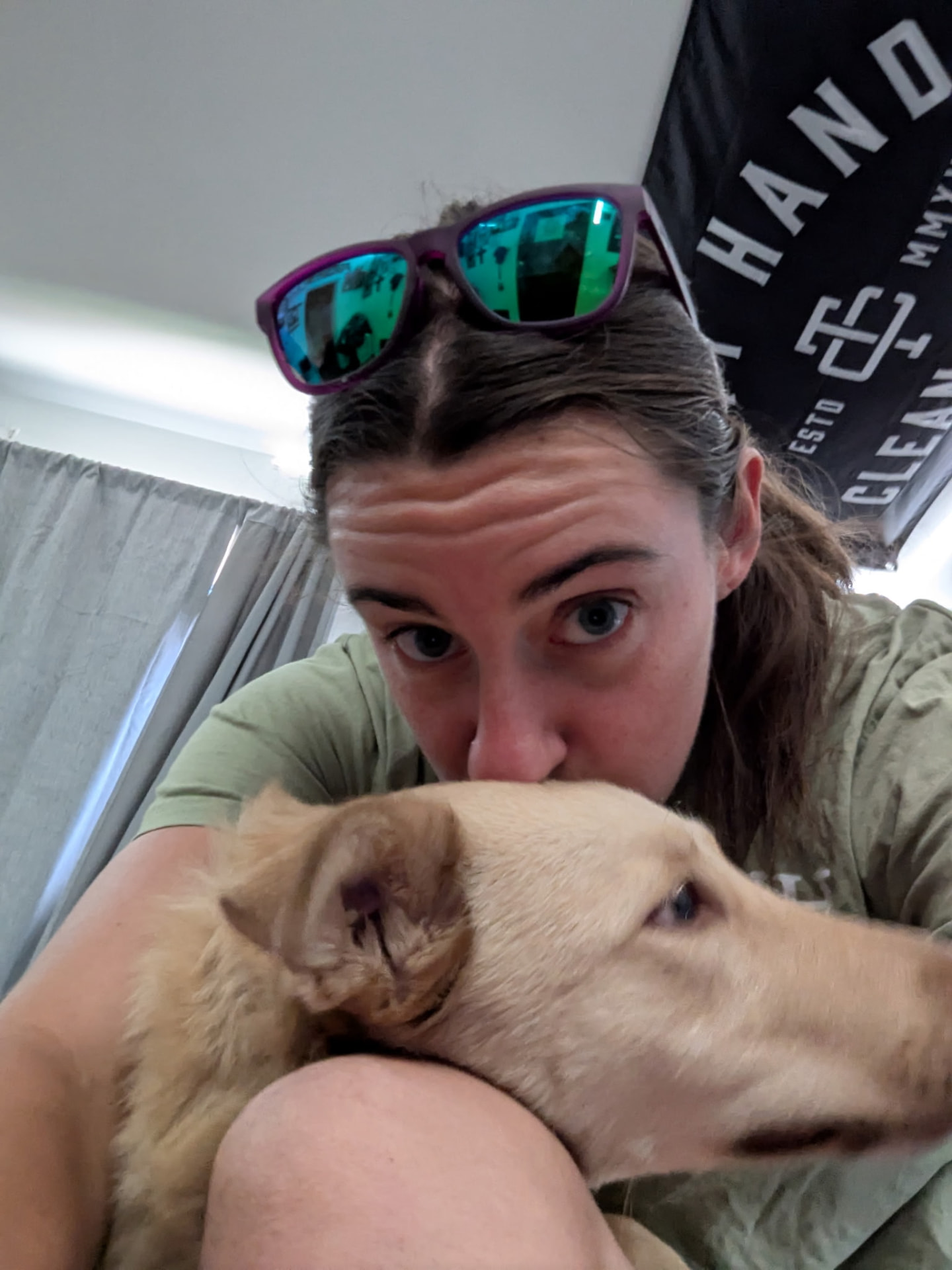 Sarah kissing the head of a calm yellow dog she is caring for